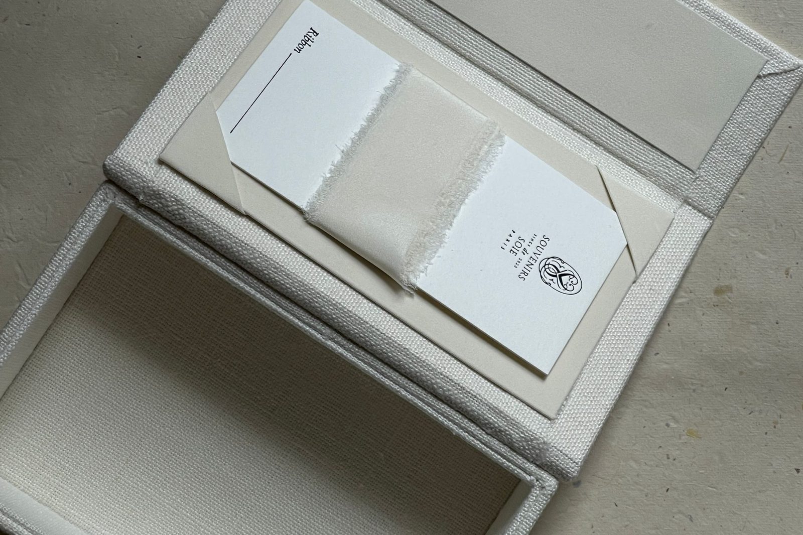 An open rigid box fitted with printed insert cards